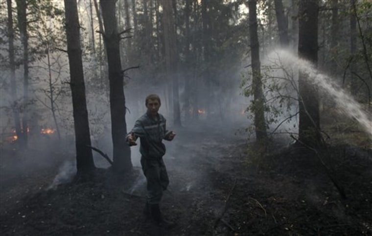 A firefighter speaks while battling a forest fire near  the village of Velino, some 140 km  (87 miles) east of Moscow, Saturday, Aug. 14, 2010. Russia has been battling the fires for nearly three weeks. The fires have destroyed provincial towns and villages, and together with the drought have cost Russia a third of its wheat crop. (AP Photo/Ivan Sekretarev)
